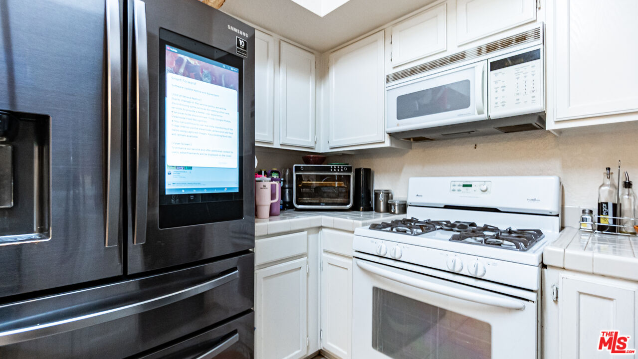 69817 Brookview Way Cathedral City, CA 92234 - Photo 11 of 38 a kitchen with stainless steel appliances granite countertop a stove and a microwave