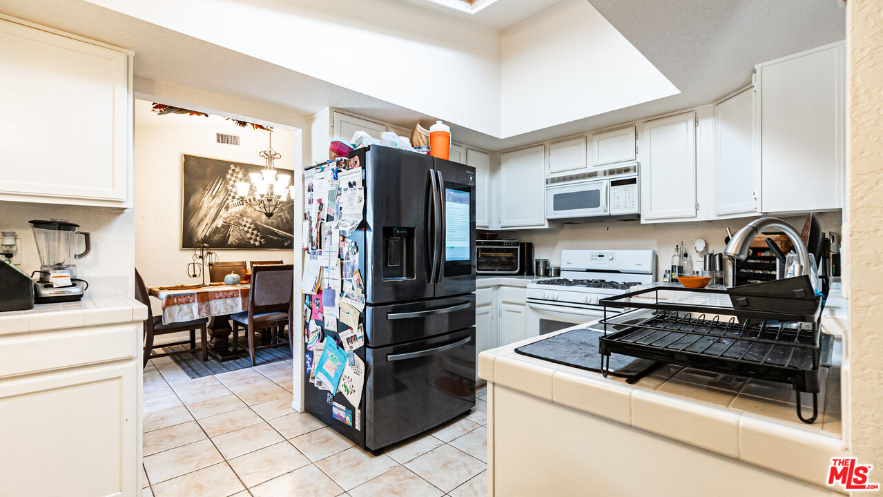 69817 Brookview Way Cathedral City, CA 92234 - Photo 8 of 38 a kitchen with a refrigerator and cabinets