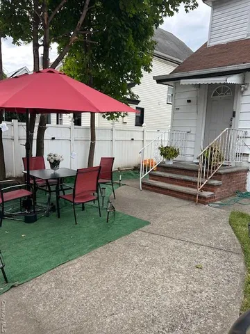 a view of a house with backyard and sitting area