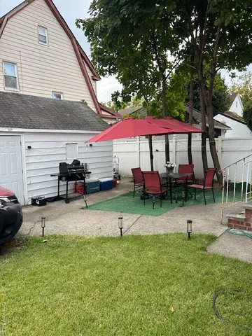 a view of a patio with a table and chairs under an umbrella