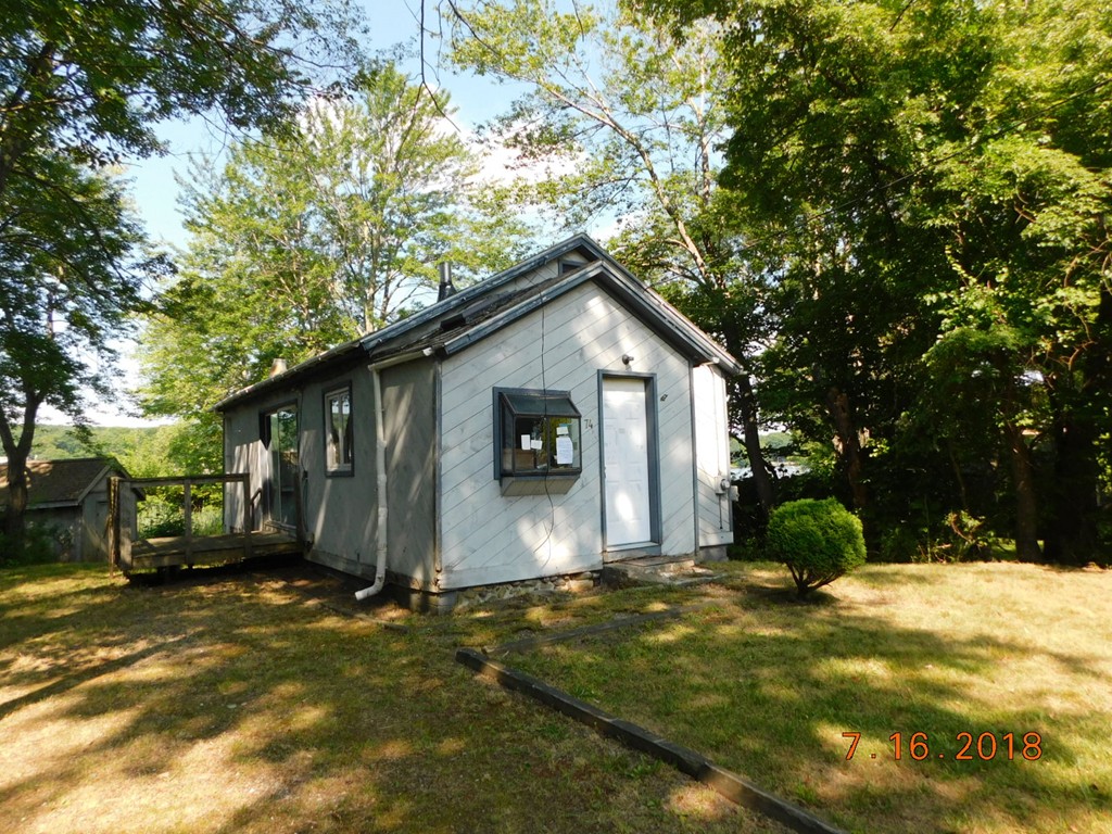 a view of a house with backyard and trees