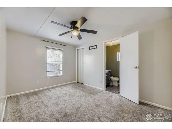 a view of empty room with wooden floor and ceiling fan