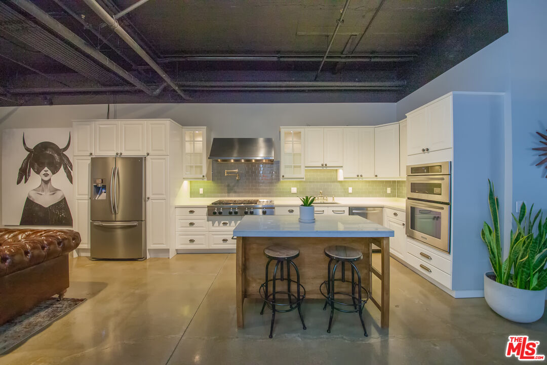 530 Molino Street, Unit 113 Los Angeles, CA 90013 - Photo 4 of 16 a kitchen with refrigerator and cabinets