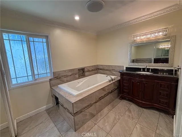 a spacious bathroom with a sink a mirror and bathtub