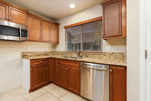 a kitchen with stainless steel appliances granite countertop a sink and a microwave
