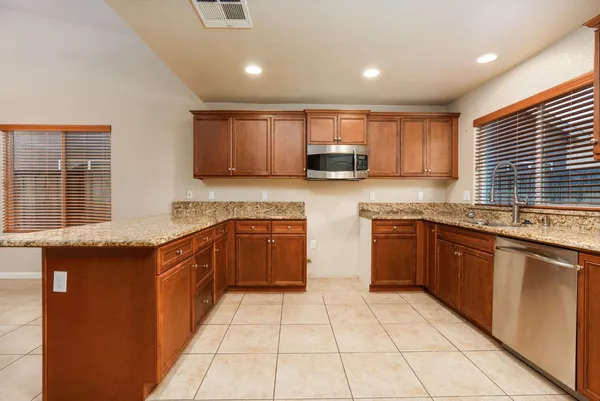 a kitchen with stainless steel appliances granite countertop a stove sink and cabinets