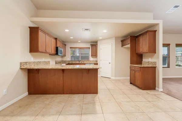 a kitchen with granite countertop a stove a sink and a refrigerator