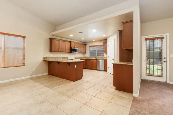 a large kitchen with stainless steel appliances granite countertop a refrigerator and a sink