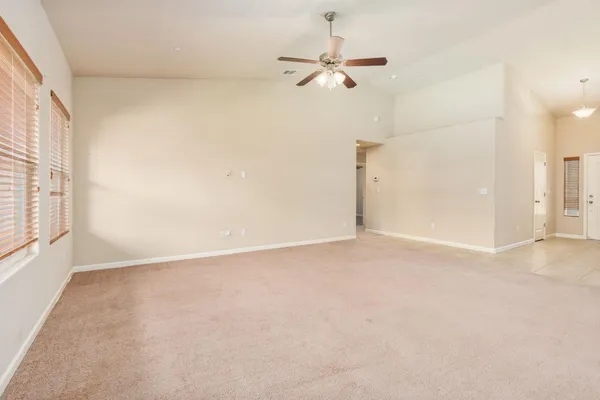 an empty room with a ceiling fan and window