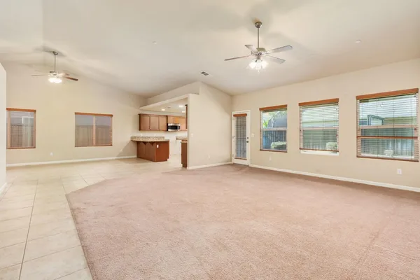 a view of an empty room with a window and fireplace