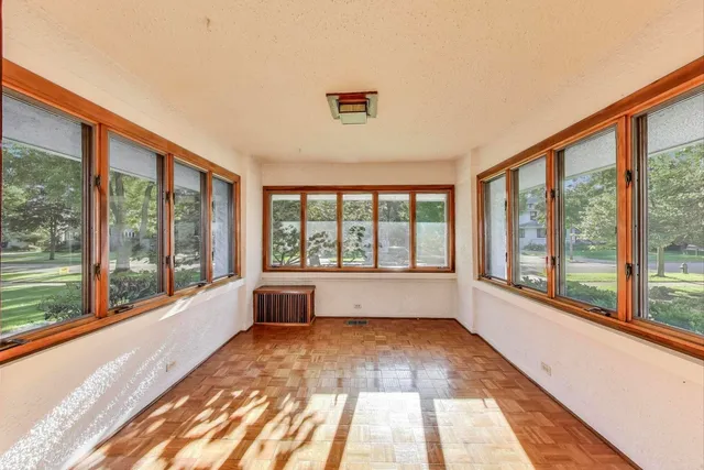 a view of empty room with wooden floor and floor to ceiling window