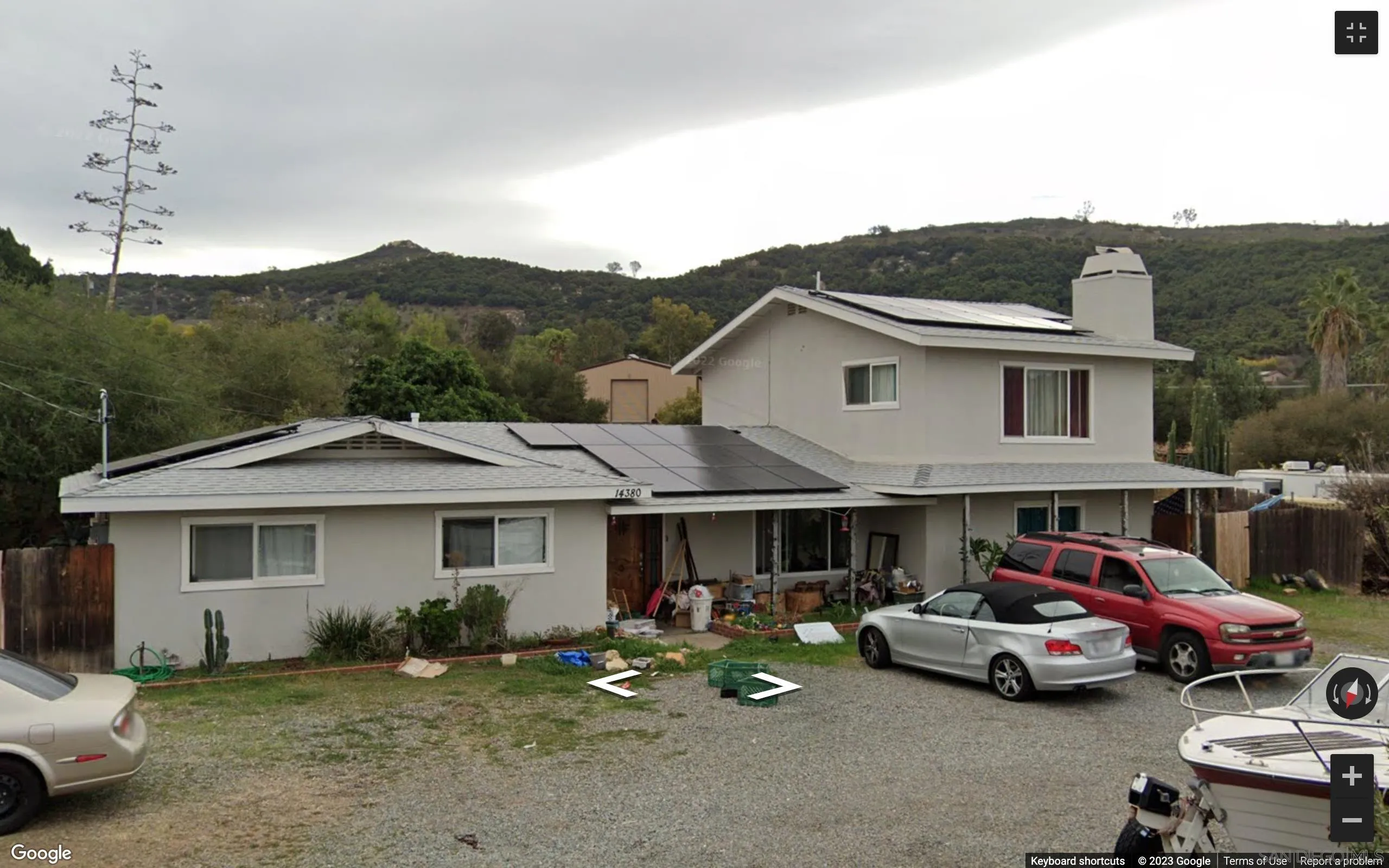 a front view of a house with a garden and parking space