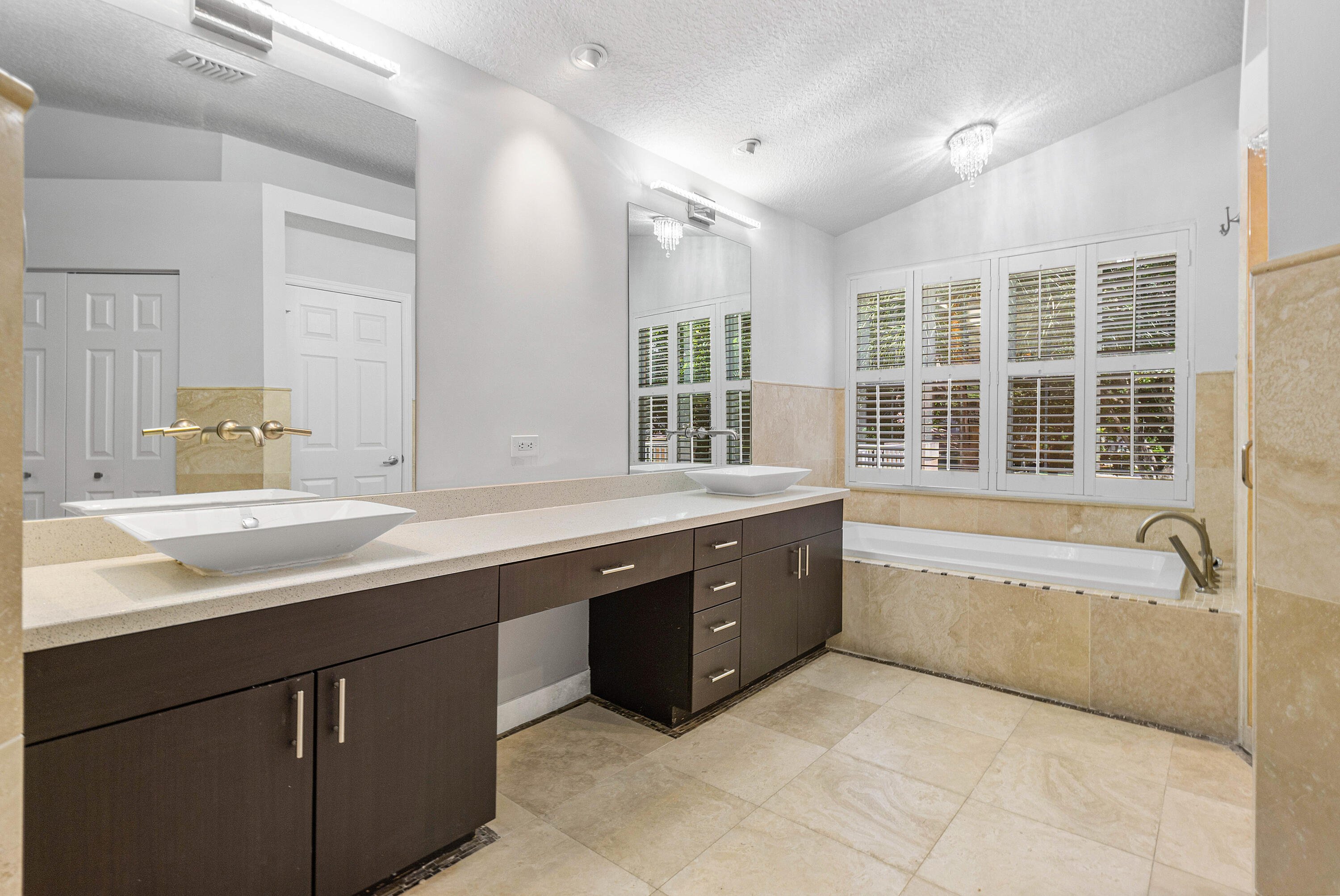 1655 East Classical Boulevard Delray Beach, FL 33445 - Photo 18 of 40 a spacious bathroom with a tub sink and mirror