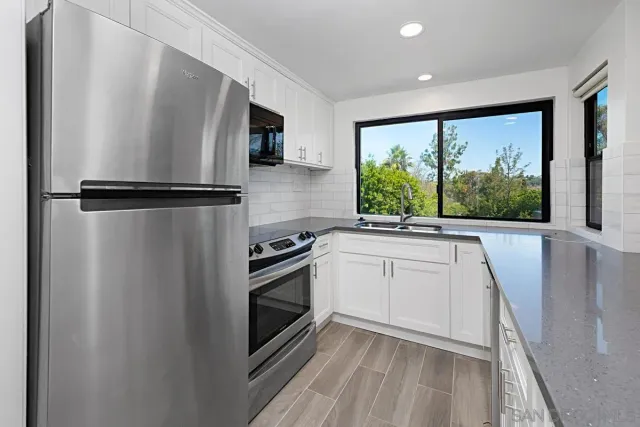 a kitchen with stainless steel appliances a refrigerator sink and cabinets
