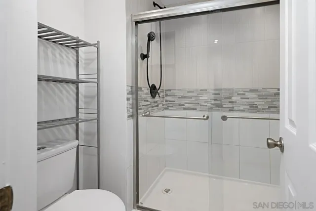 a bathroom with a granite countertop sink a toilet and shower