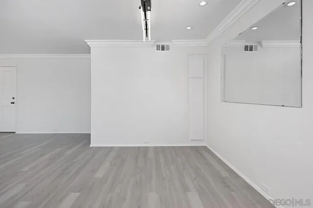 a view of a room with wooden floor and white walls