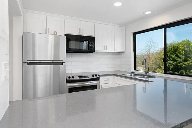 a kitchen with stainless steel appliances a refrigerator sink and microwave