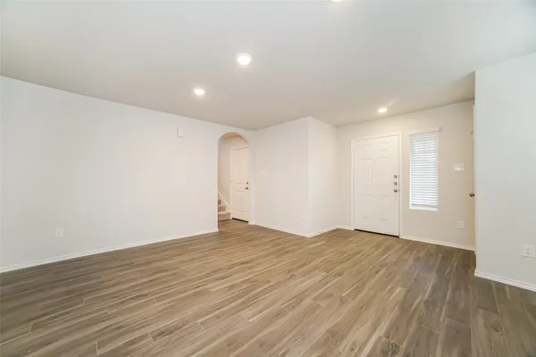 a view of an empty room with wooden floor