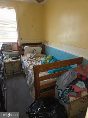 a bed sitting in a bedroom next to a window