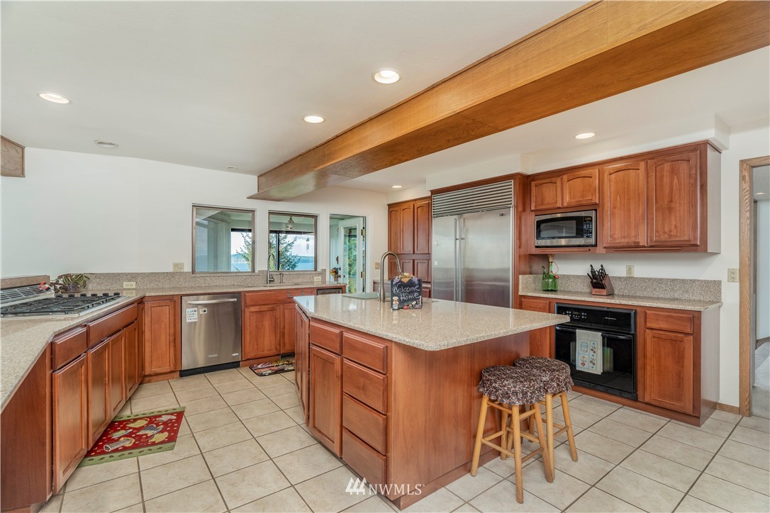 2604 Madrona Point Lane Steilacoom, WA 98388 - Photo 4 of 25 a kitchen with sink a stove and chairs