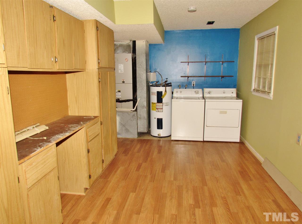 7813 Nugget Lane Raleigh, NC 27615 - Photo 18 of 25 a kitchen with a refrigerator a stove and wooden floor