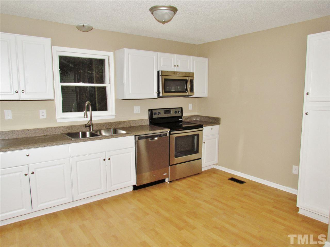 7813 Nugget Lane Raleigh, NC 27615 - Photo 5 of 25 a kitchen with granite countertop a sink cabinets and stainless steel appliances