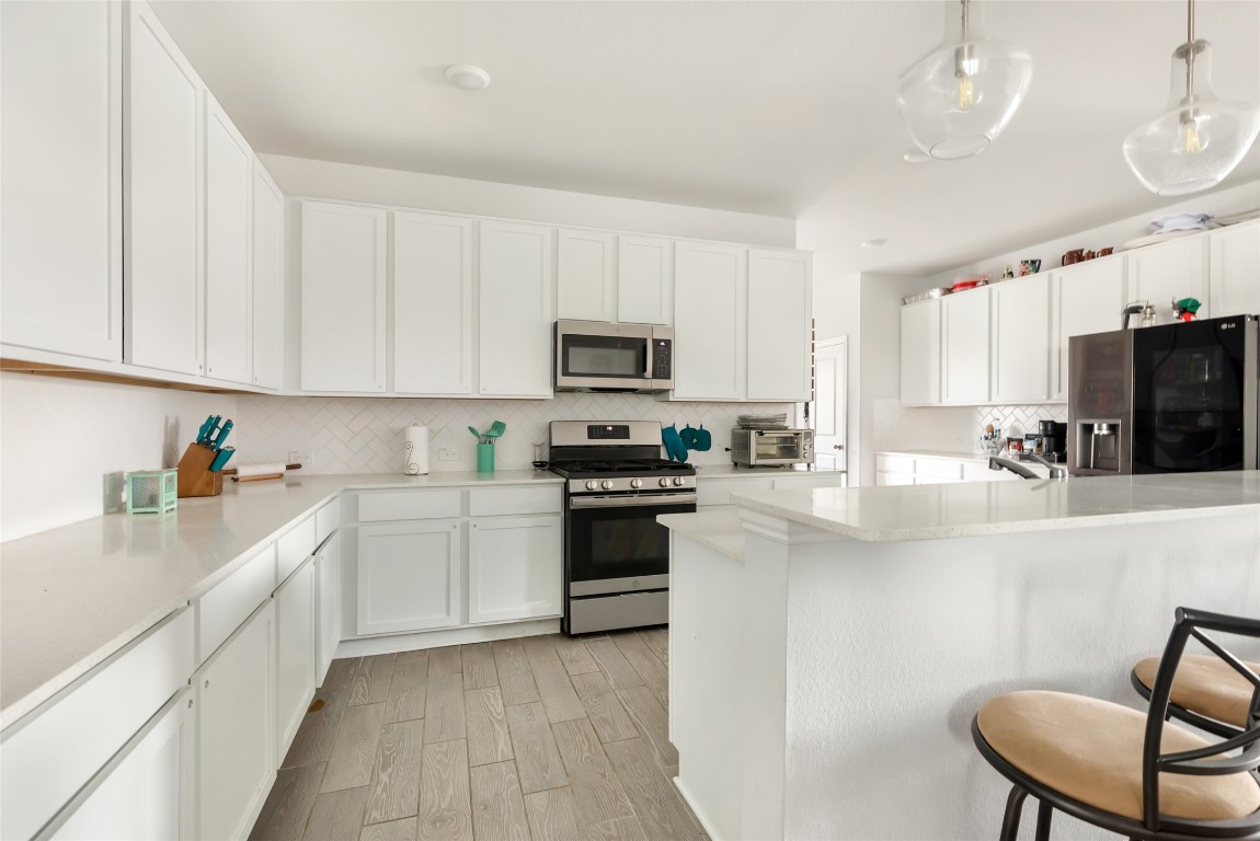 9910 Pine Forest Baytown, TX 77521 - Photo 11 of 26 a kitchen with stainless steel appliances granite countertop a stove top oven a sink dishwasher and a refrigerator with wooden floor
