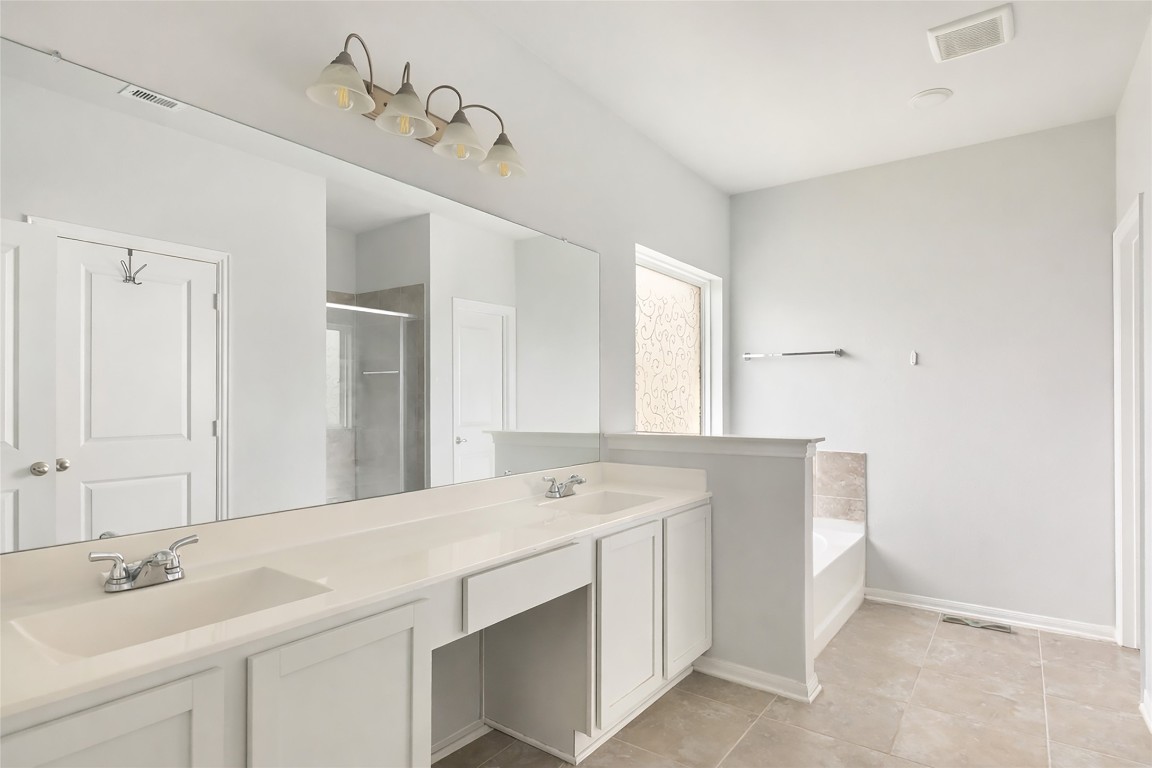 9910 Pine Forest Baytown, TX 77521 - Photo 18 of 26 a spacious bathroom with a sink double vanity and a mirror