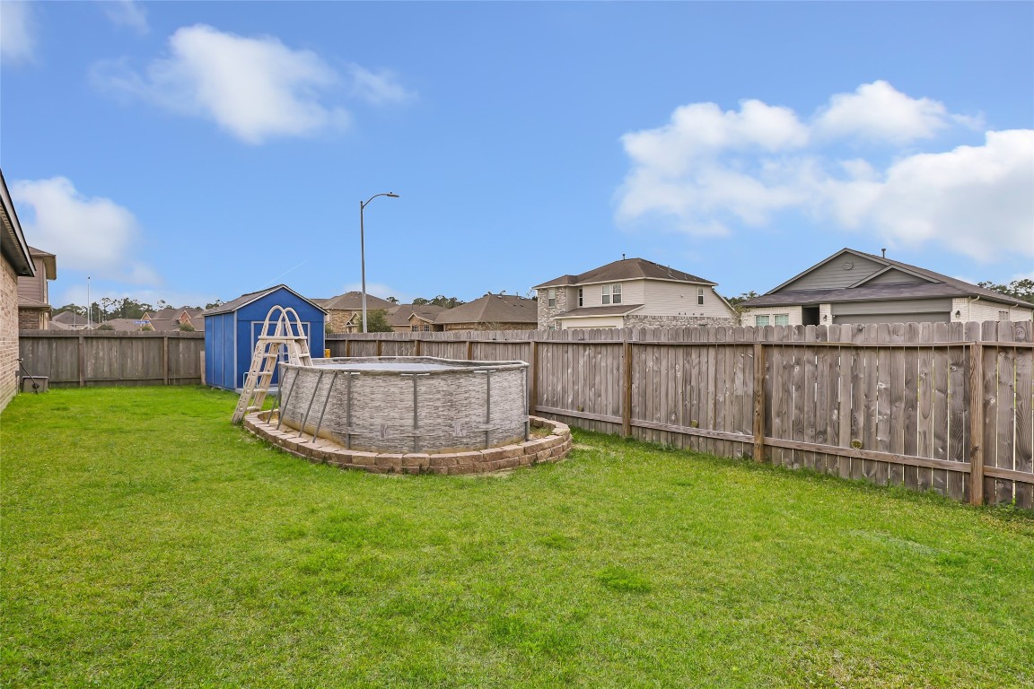 9910 Pine Forest Baytown, TX 77521 - Photo 23 of 26 a view of a small yard with large trees and wooden fence