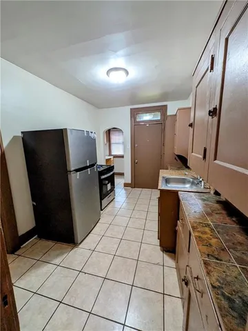 a kitchen with granite countertop a refrigerator and a stove top oven