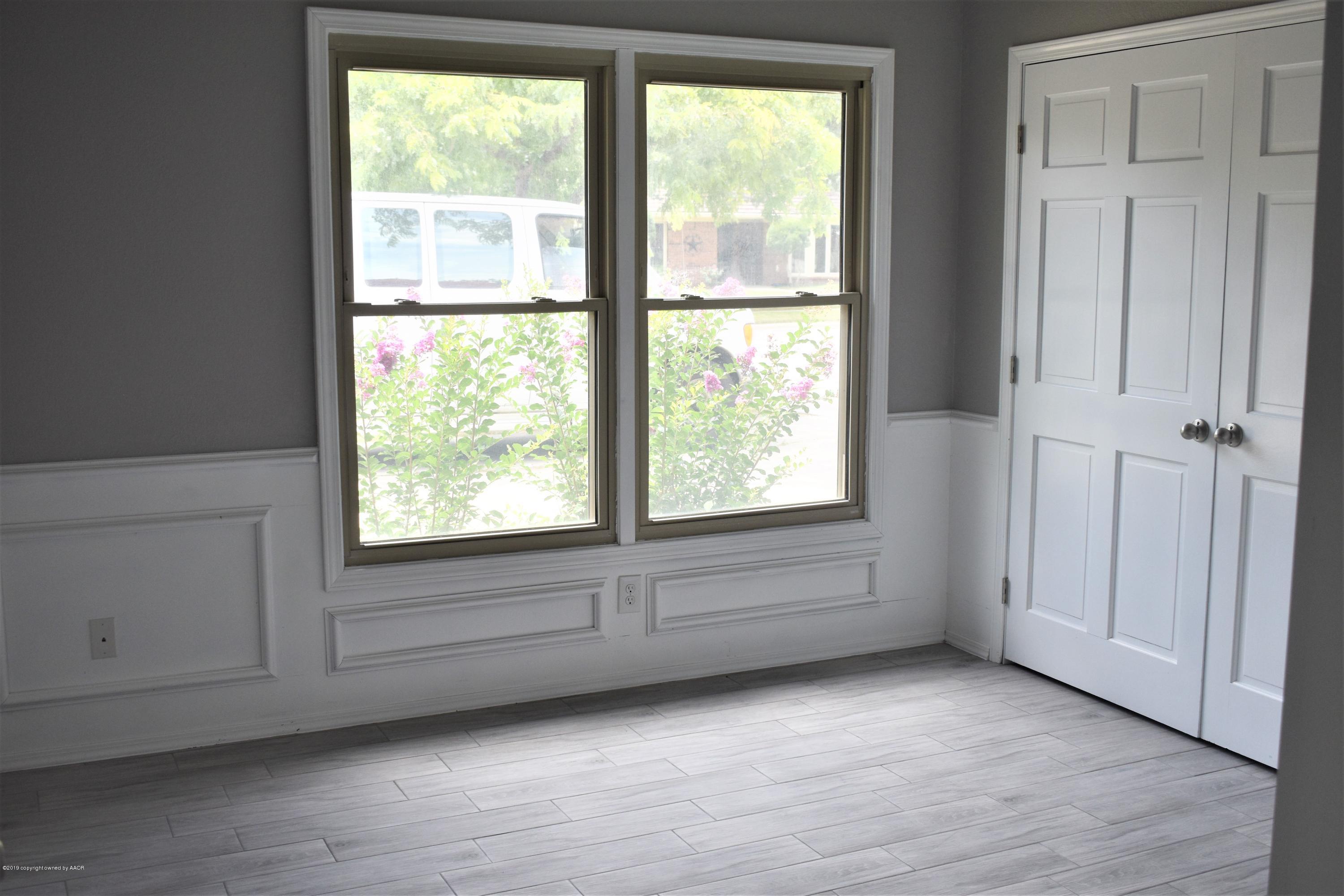 7516 Tripp Avenue Amarillo, TX 79121 - Photo 12 of 33 an empty room with wooden floor and windows