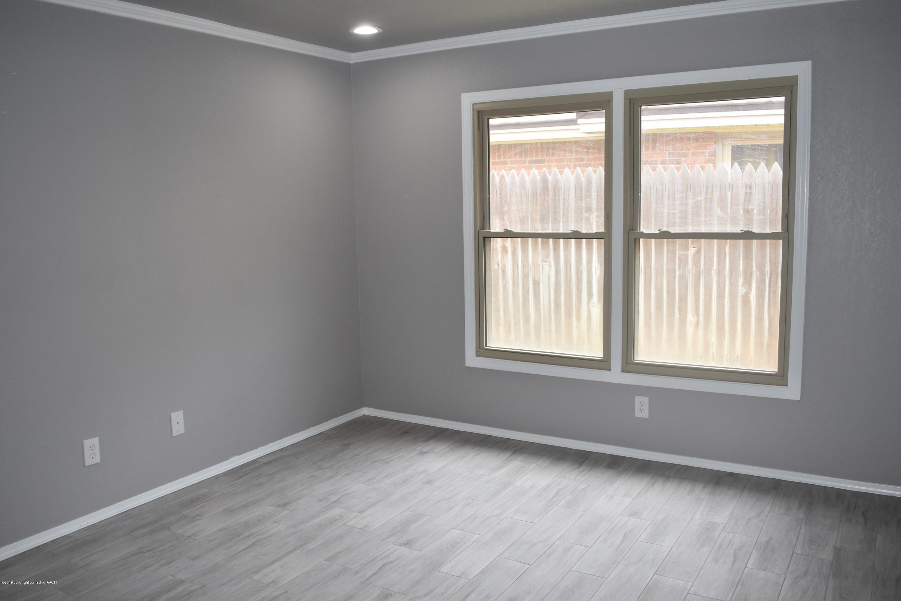 7516 Tripp Avenue Amarillo, TX 79121 - Photo 17 of 33 an empty room with wooden floor and windows