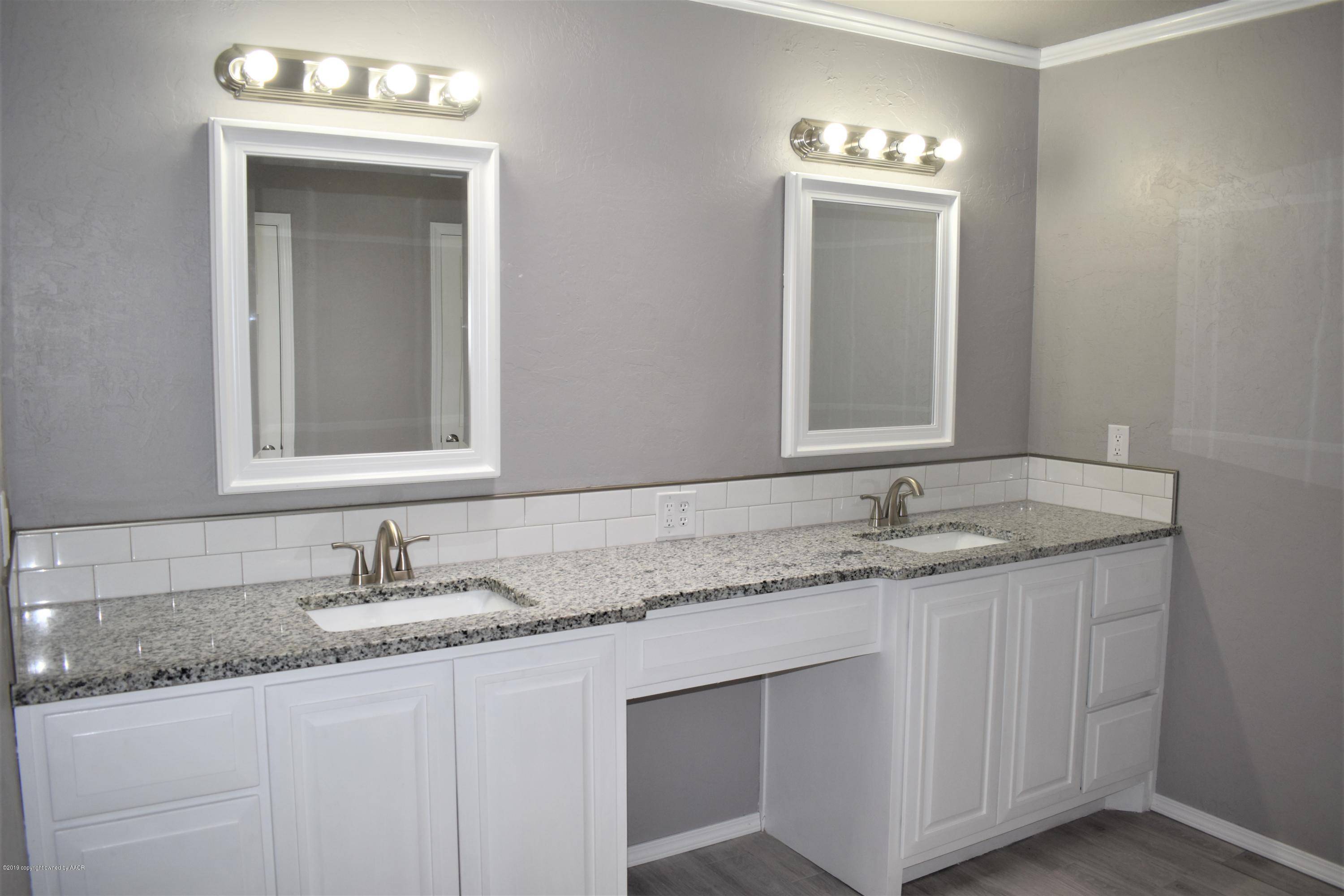 7516 Tripp Avenue Amarillo, TX 79121 - Photo 20 of 33 a bathroom with a granite countertop sink and a mirror