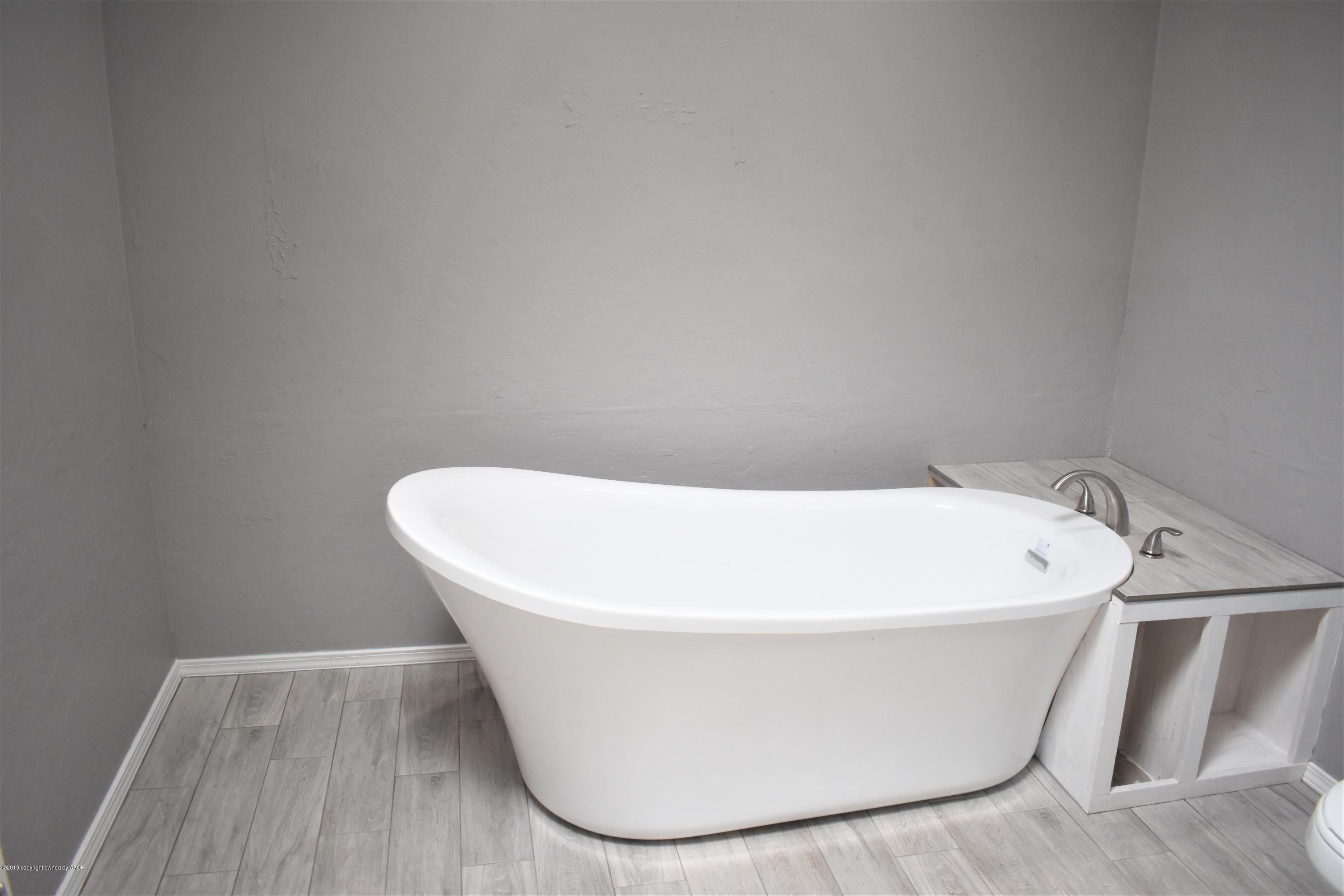 7516 Tripp Avenue Amarillo, TX 79121 - Photo 24 of 33 a white bath tub sitting in a bathroom