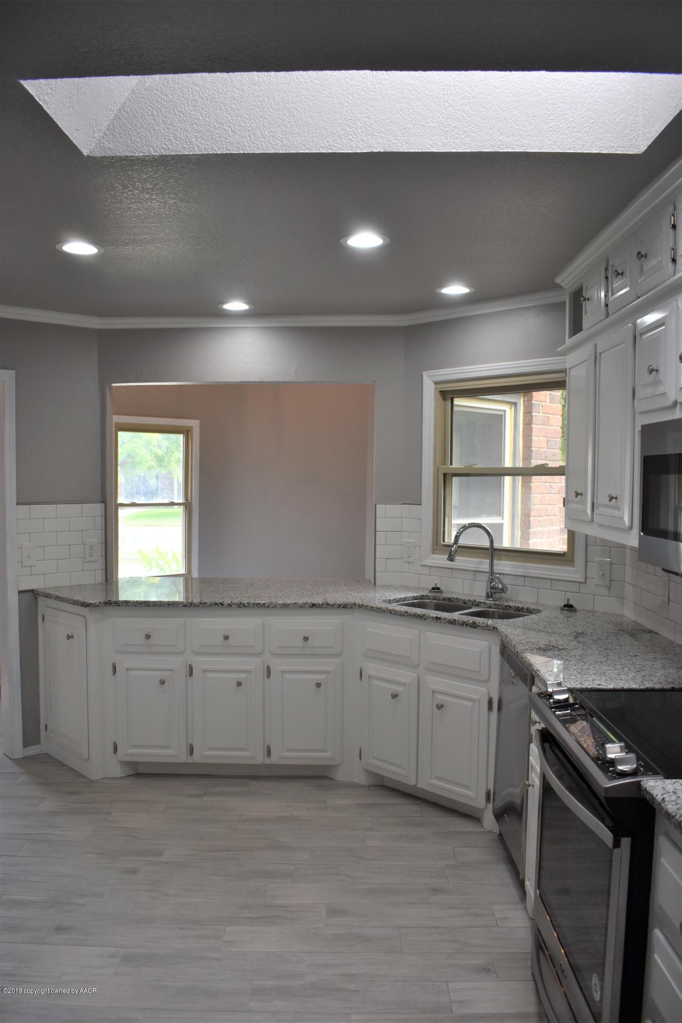 7516 Tripp Avenue Amarillo, TX 79121 - Photo 29 of 33 a kitchen with granite countertop white cabinets and a sink