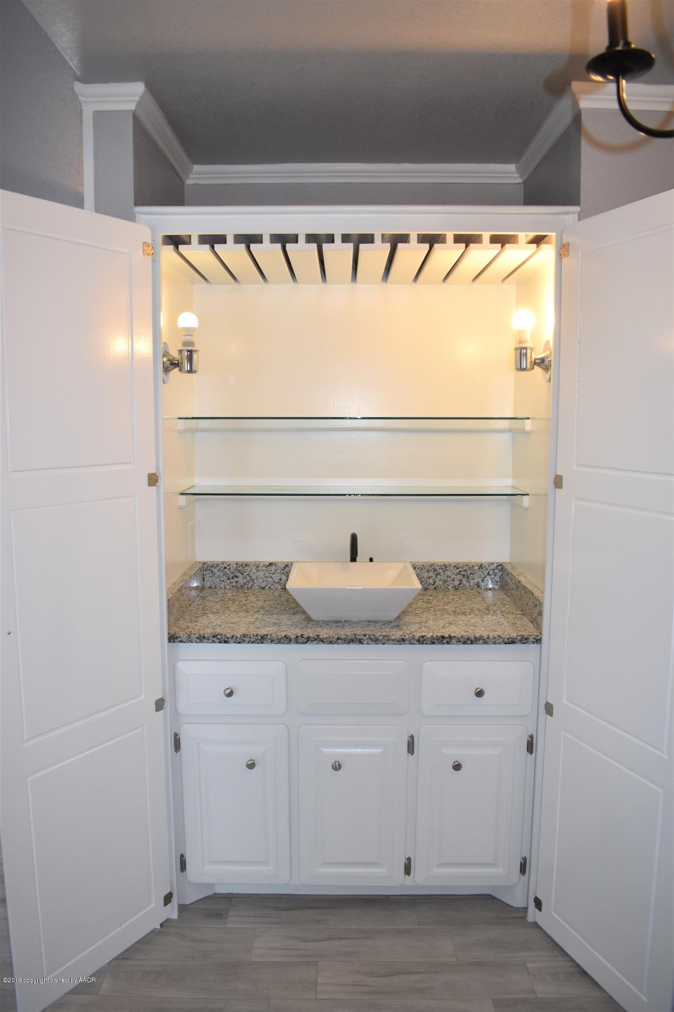 7516 Tripp Avenue Amarillo, TX 79121 - Photo 8 of 33 a view of granite countertop with white cabinets and a wooden floor