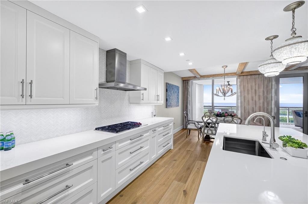 13915 Old Coast Road, Unit 1503 Naples, FL 34110 - Photo 11 of 49 a large white kitchen with cabinets