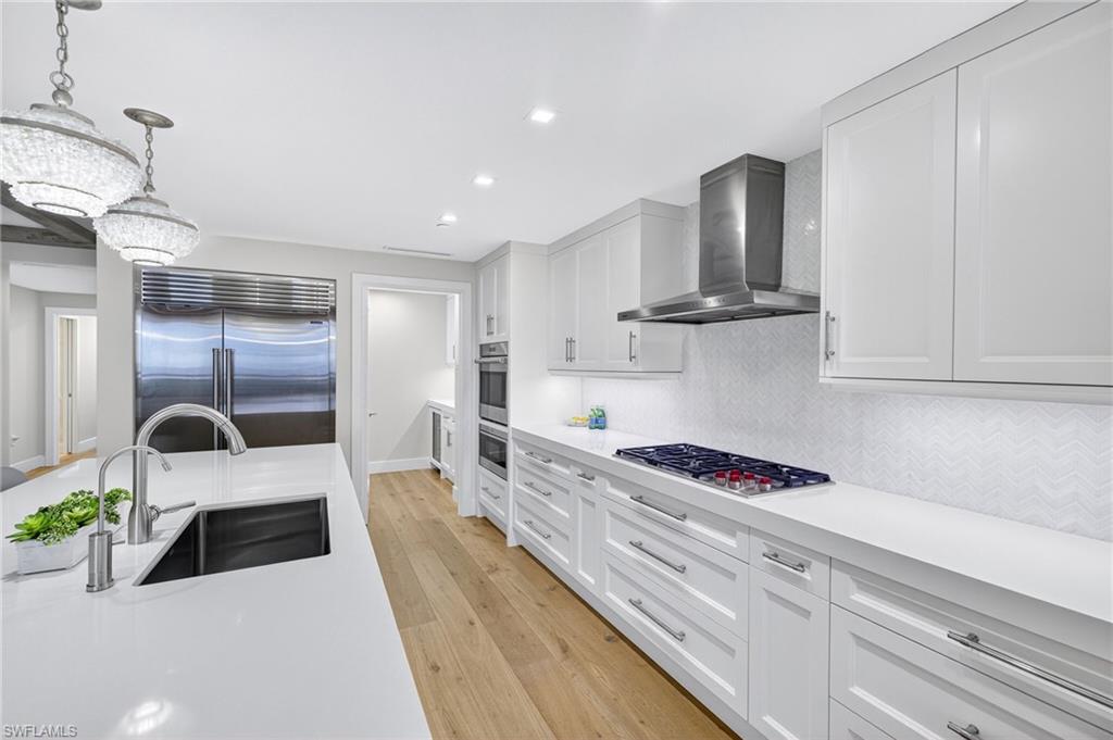 13915 Old Coast Road, Unit 1503 Naples, FL 34110 - Photo 12 of 49 a kitchen with stainless steel appliances kitchen island granite countertop a sink a stove and cabinets