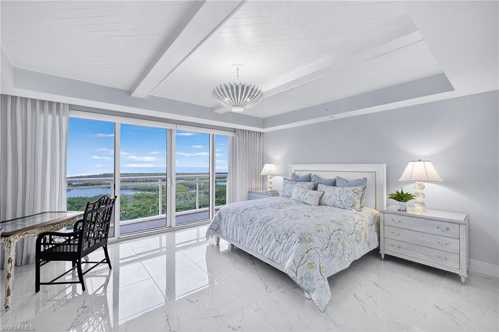 13915 Old Coast Road, Unit 1503 Naples, FL 34110 - Photo 14 of 49 a bedroom with a bed and a night stand