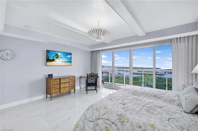 a bedroom with furniture and a large window