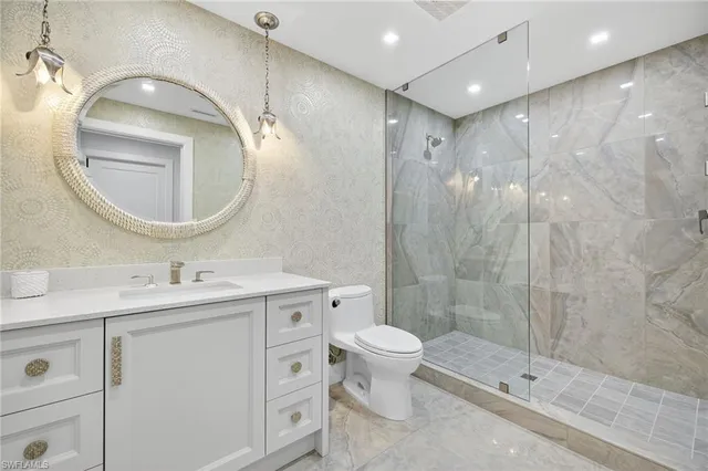a bathroom with a double vanity sink toilet mirror and shower