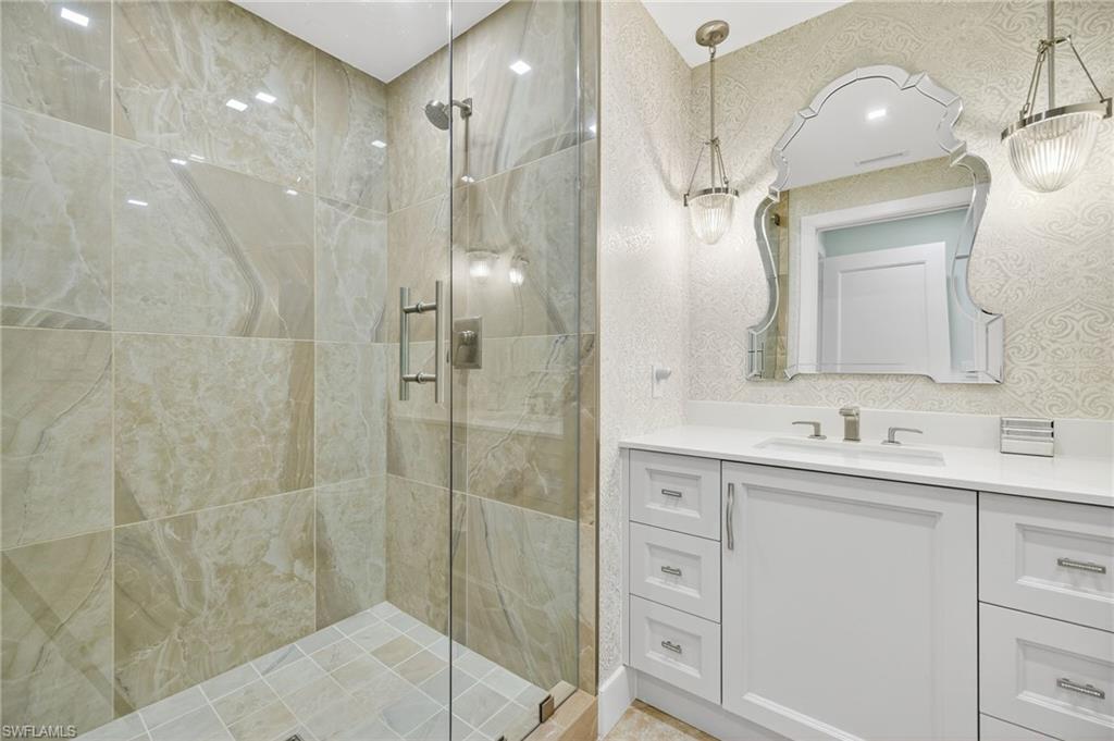 13915 Old Coast Road, Unit 1503 Naples, FL 34110 - Photo 22 of 49 a bathroom with a double vanity sink mirror and shower