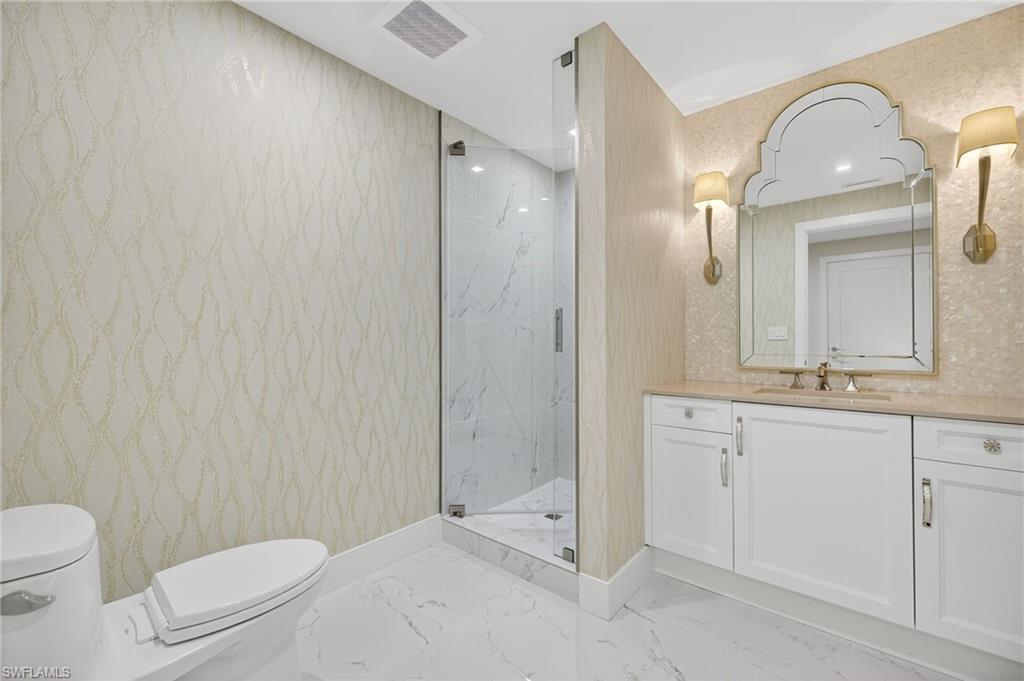13915 Old Coast Road, Unit 1503 Naples, FL 34110 - Photo 27 of 49 a bathroom with a toilet a sink and mirror