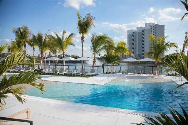 a front view of residential houses with yard and palm trees