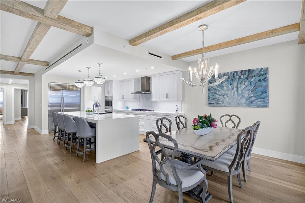 13915 Old Coast Road, Unit 1503 Naples, FL 34110 - Photo 9 of 49 a view of a dining room and livingroom with furniture wooden floor a chandelier
