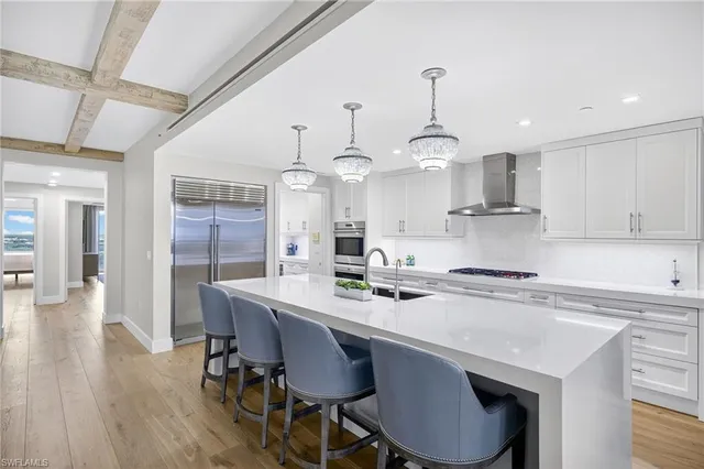 a kitchen with stainless steel appliances a table chairs refrigerator and cabinets