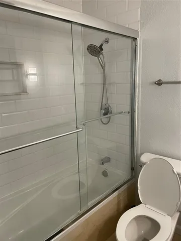 a bathroom with a toilet and a shower