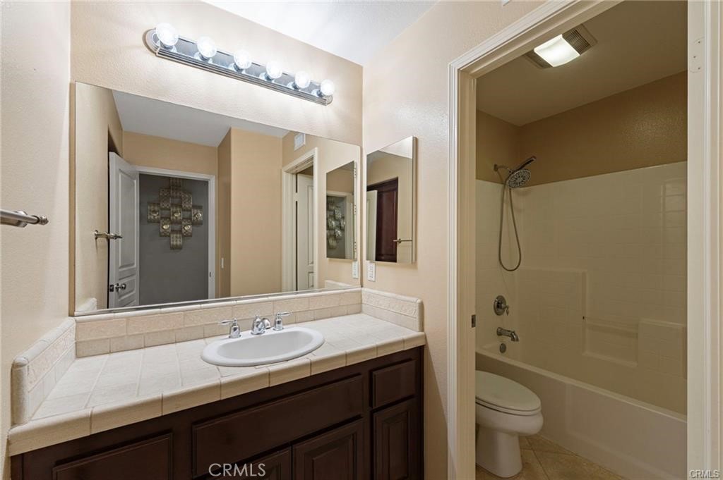 8634 Hunt Canyon Road Corona, CA 92883 - Photo 14 of 31 a bathroom with a double vanity sink toilet mirror and bathtub