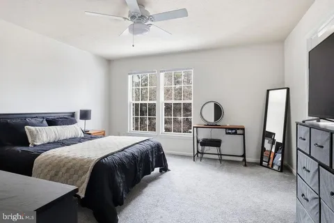 a bedroom with a bed furniture and a large window