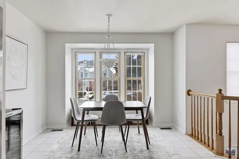 a dining room with furniture a chandelier and window